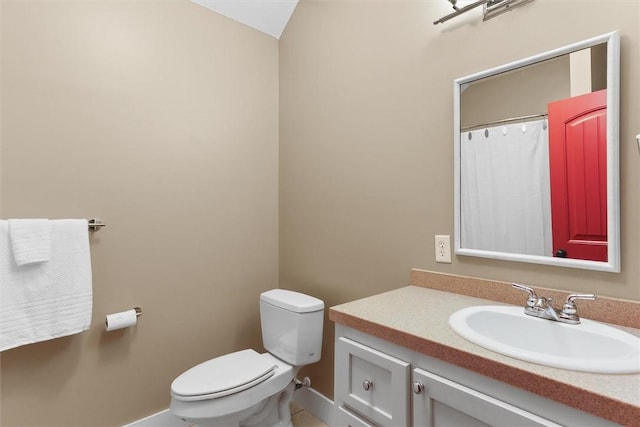 bathroom featuring vanity, baseboards, tile patterned flooring, and toilet