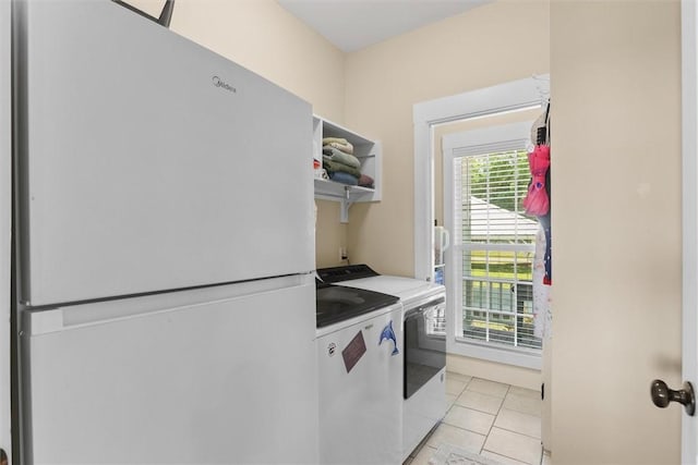 laundry area with baseboards, laundry area, washing machine and dryer, and light tile patterned floors