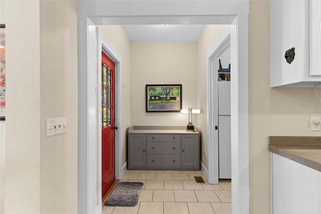 corridor with light tile patterned floors, baseboards, and visible vents
