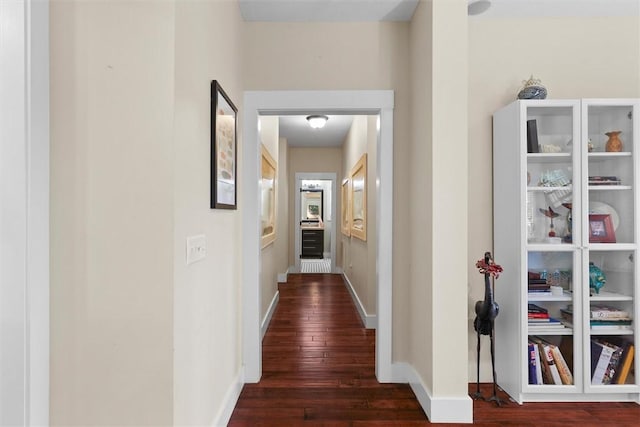 hall featuring baseboards and wood finished floors