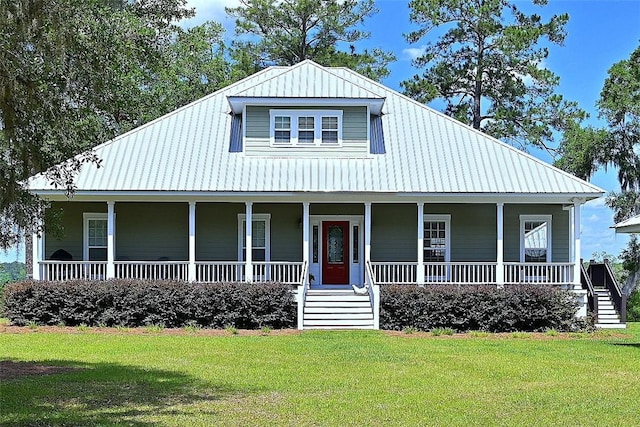 country-style home featuring a front yard, a porch, and metal roof