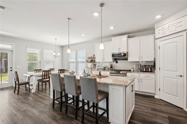 140 Clearwater Dr, Brunswick, GA 31523 - kitchen with a breakfast bar area, stainless steel appliances, backsplash, dark wood-style flooring, and white cabinetry
