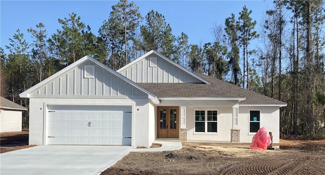 modern farmhouse with board and batten siding, a shingled roof, concrete driveway, french doors, and an attached garage