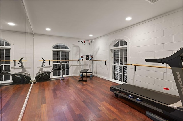 workout area with crown molding and dark hardwood / wood-style flooring