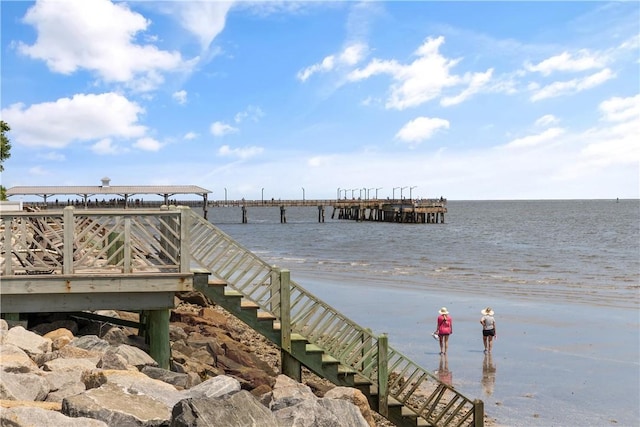 view of dock featuring a view of the beach and a water view