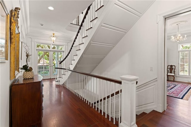 staircase with crown molding, french doors, a healthy amount of sunlight, and hardwood / wood-style flooring