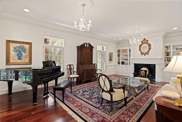 living room featuring built in features, dark wood-type flooring, a notable chandelier, and ornamental molding