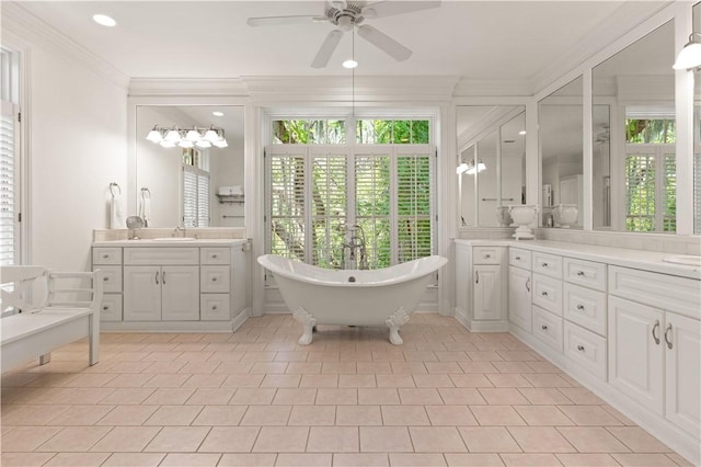 bathroom featuring a tub to relax in, a wealth of natural light, ceiling fan, and ornamental molding