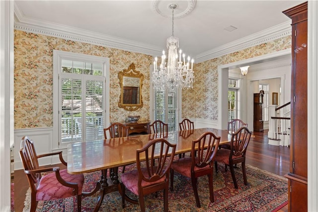 dining area with crown molding, dark hardwood / wood-style flooring, and an inviting chandelier