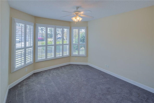 carpeted empty room with baseboards and a ceiling fan