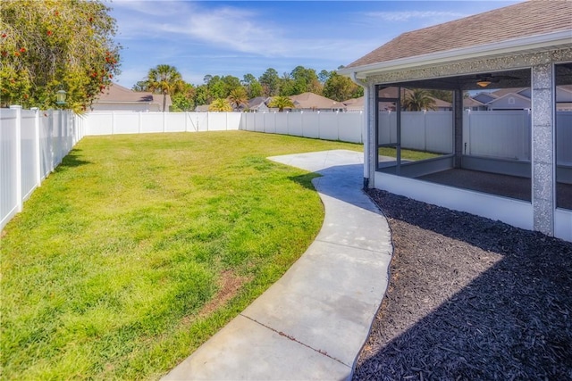 view of yard featuring a sunroom, a fenced backyard, and a patio area