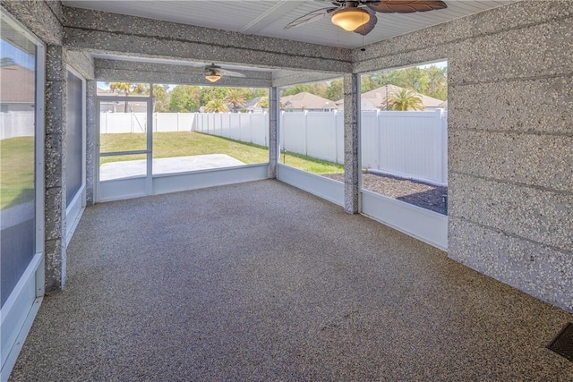 unfurnished sunroom featuring ceiling fan