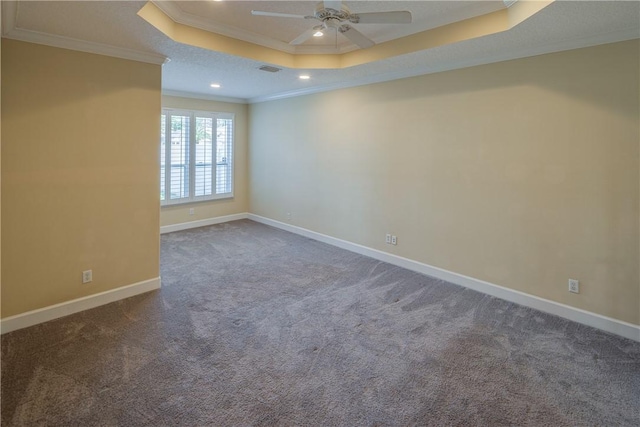 empty room featuring ornamental molding, a ceiling fan, carpet floors, a raised ceiling, and baseboards