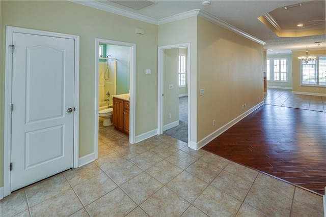 hall with light tile patterned floors, a notable chandelier, baseboards, and crown molding