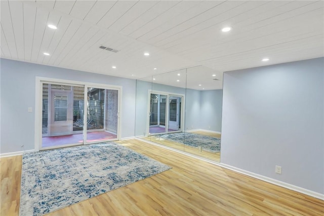 unfurnished room with light hardwood / wood-style floors, a healthy amount of sunlight, and wood ceiling