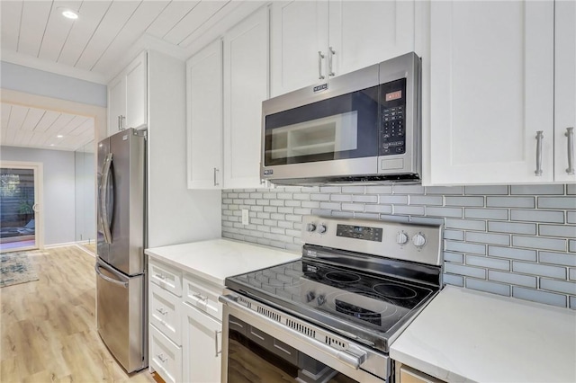 kitchen featuring tasteful backsplash, white cabinetry, light wood-type flooring, and appliances with stainless steel finishes