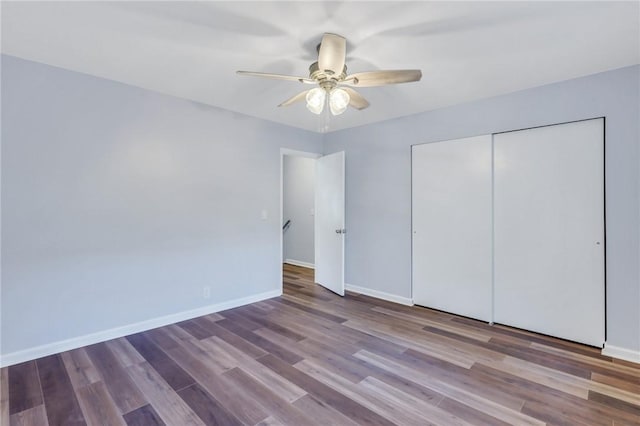 unfurnished bedroom featuring ceiling fan, a closet, and hardwood / wood-style flooring