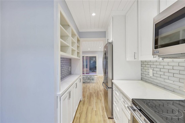 kitchen featuring white cabinets, appliances with stainless steel finishes, and tasteful backsplash