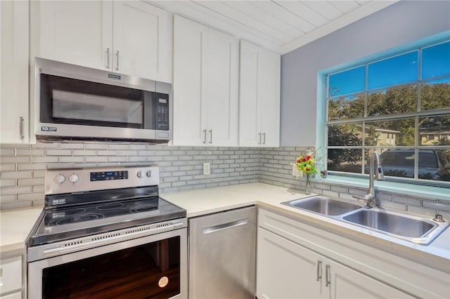 kitchen with tasteful backsplash, sink, white cabinets, and stainless steel appliances