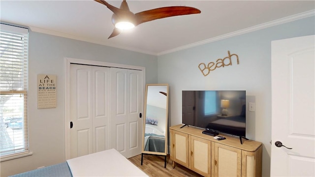 bedroom with light wood-style flooring, a closet, and ornamental molding