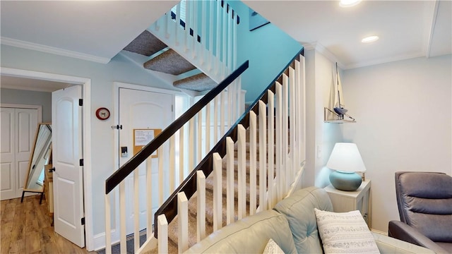 staircase with recessed lighting, wood finished floors, and ornamental molding