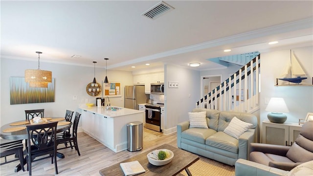 living room with stairway, visible vents, light wood-style flooring, recessed lighting, and crown molding