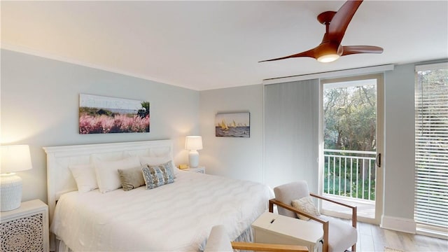 bedroom featuring access to outside, wood finished floors, and ceiling fan