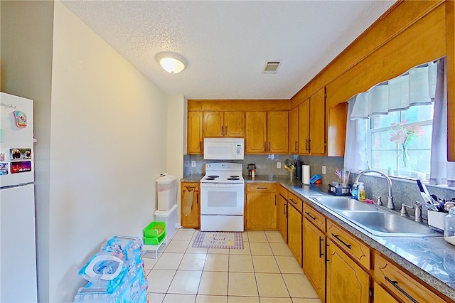 940 Azalea St, Blackshear, GA 31516 - kitchen featuring white appliances, a sink, light tile patterned floors, brown cabinets, and backsplash