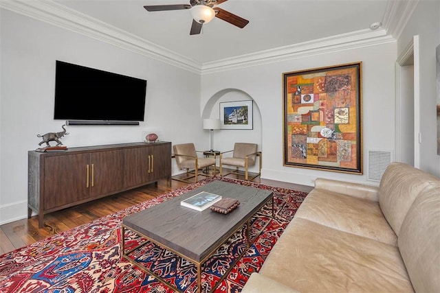 living room with ceiling fan, crown molding, and dark wood-type flooring