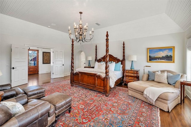 bedroom featuring an inviting chandelier and hardwood / wood-style flooring