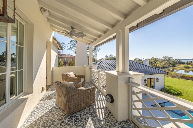 view of patio / terrace with a balcony, ceiling fan, and a water view