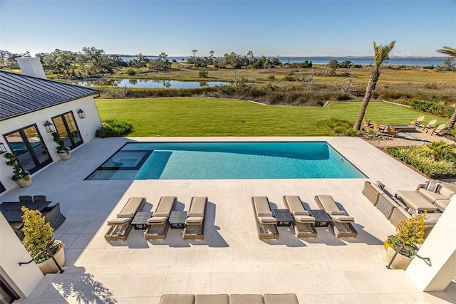 view of pool with a patio, a yard, and a water view