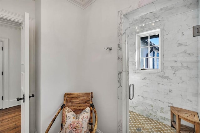 bathroom with ornamental molding and a shower with shower door