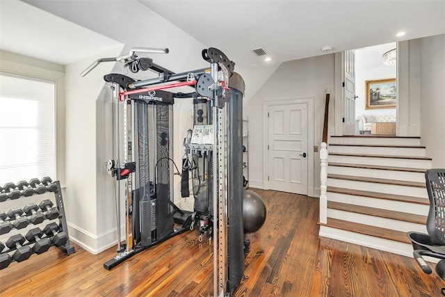 workout room featuring dark hardwood / wood-style flooring and vaulted ceiling