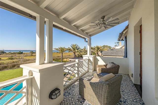 view of patio / terrace with ceiling fan, a balcony, and a water view