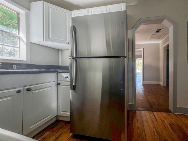 kitchen featuring dark wood finished floors, white cabinets, and freestanding refrigerator
