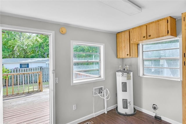 washroom featuring hookup for a washing machine, water heater, cabinet space, dark wood-style flooring, and baseboards