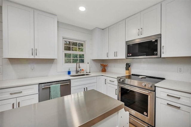 kitchen with appliances with stainless steel finishes, sink, and white cabinets