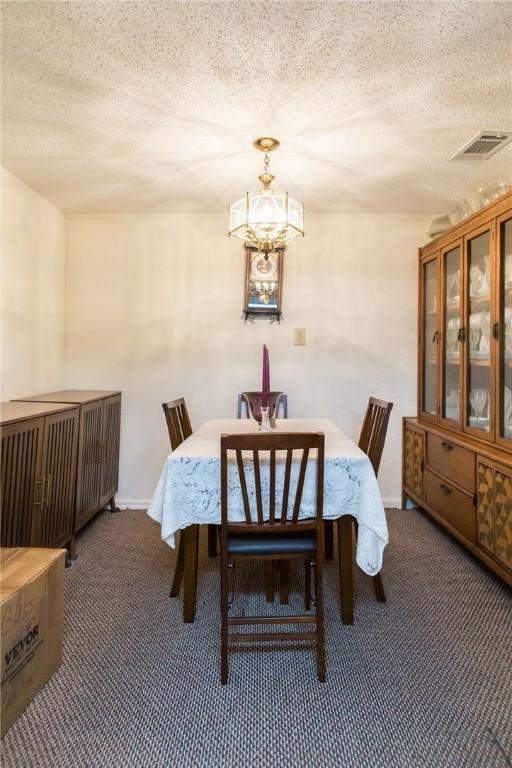 2896 S Lakeview Dr, Waycross, GA 31503 - dining room featuring carpet, a chandelier, and a textured ceiling