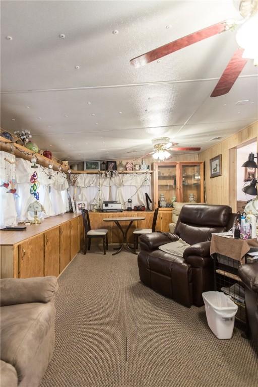 2896 S Lakeview Dr, Waycross, GA 31503 - living room featuring a ceiling fan, carpet, and wood walls