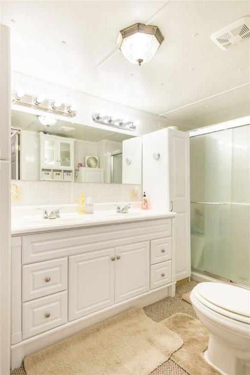 2896 S Lakeview Dr, Waycross, GA 31503 - bathroom featuring a shower with door, toilet, double vanity, and tile patterned flooring