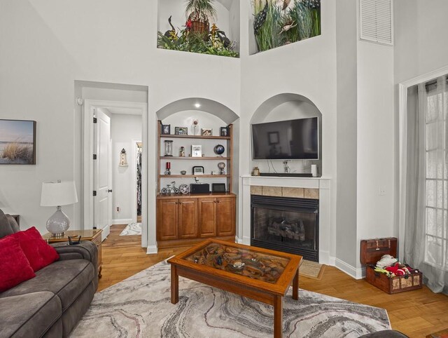 108 Fox Run Dr, Brunswick, GA 31525 - living room with a tile fireplace, plenty of natural light, light wood finished floors, visible vents, and a towering ceiling