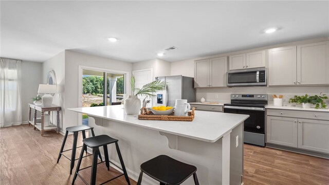 331 Elizabeth Dr, Brunswick, GA 31525 - kitchen with stainless steel appliances, gray cabinetry, a breakfast bar area, a center island, and light countertops