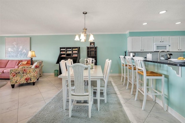 dining area with light tile patterned flooring, crown molding, and baseboards