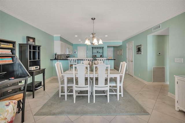 dining space featuring ornamental molding, visible vents, and a notable chandelier