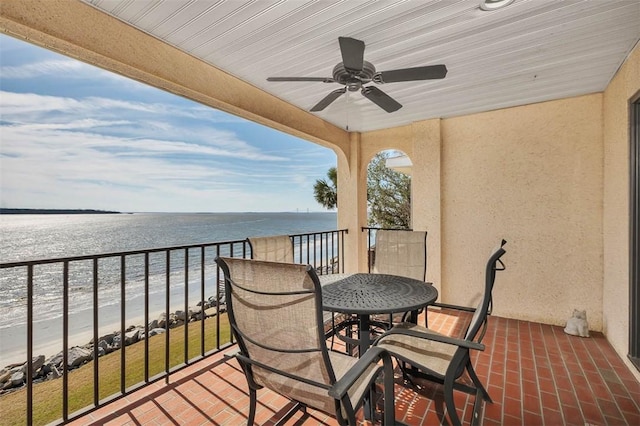 balcony with ceiling fan, a water view, and a view of the beach