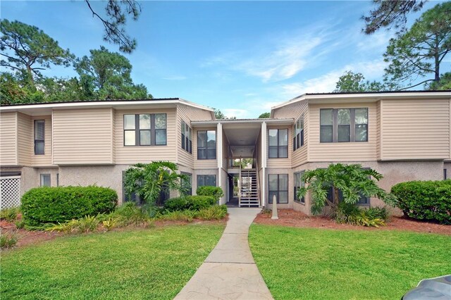 townhome / multi-family property featuring a front lawn