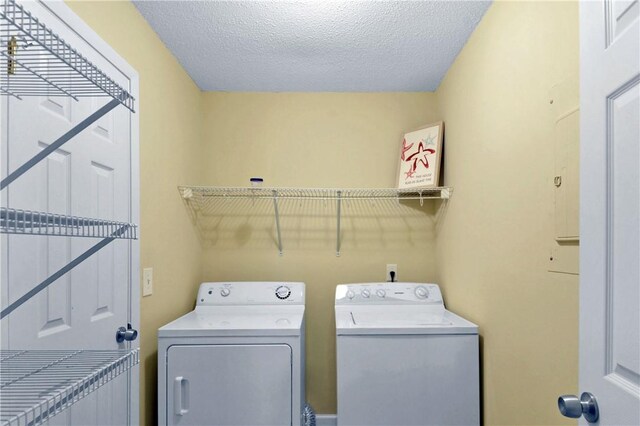 laundry area featuring washer and clothes dryer and a textured ceiling