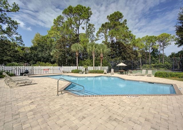 community pool featuring fence and a patio area