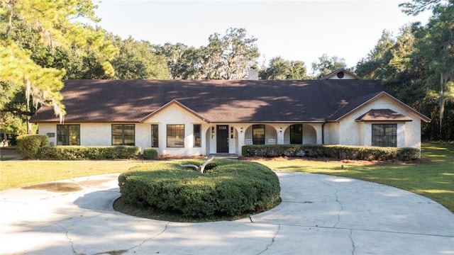 view of front of house featuring a porch, a chimney, and a front lawn